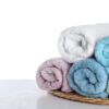 Fresh towels on wooden table against white background. Space for