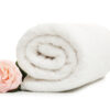 Clean rolled towel with flower on white background